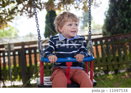 Beautiful toddler boy having fun on swing 11097538