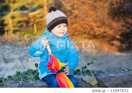Beautiful toddler boy in blue clothes with umbrella 11097652