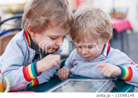 Two little sibling boys having fun together with tablet pc. Two little sibling boys having fun together with tablet pc. 11098146