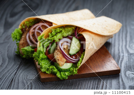 pair of fresh juicy wrap sandwiches with chicken and vegetables pair of fresh juicy wrap sandwiches with chicken and vegetables 11100415