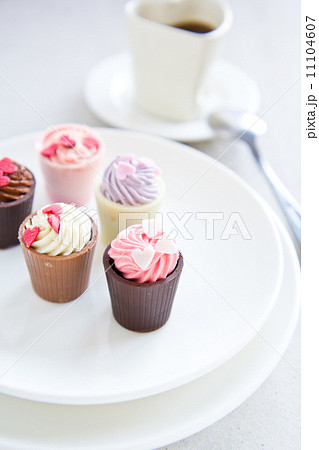Small cup with heart shape chocolate on white plates 11104607