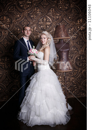 happy groom and the charming bride with a bouquet from roses in studio on a brown background happy groom and the charming bride with a bouquet from roses in studio on a brown background 11106048