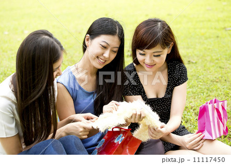 Girl friends sharing shopping items feeling happy Girl friends sharing shopping items feeling happy 11117450