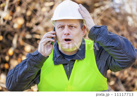 Surprised worker with cell phone 11117713