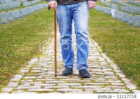 Man with walking stick in cemetery 11117718
