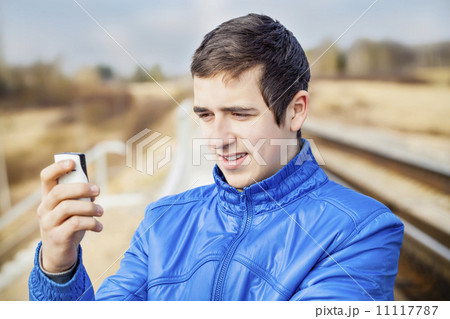 Teen with cell phone on the railway 11117787