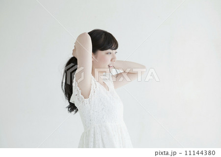 髪を束ねる若い女性の写真素材