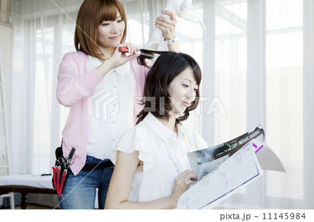 髪をセットする美容師 11145984