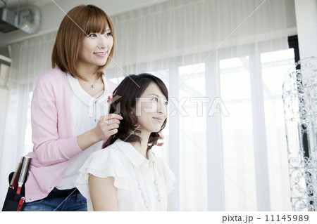 髪をセットする美容師 11145989