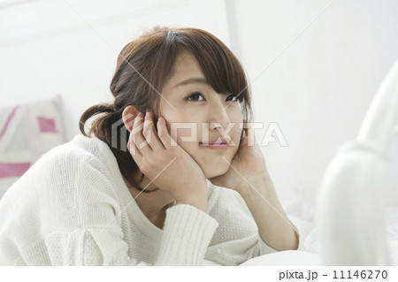 笑顔で頬杖をつく女子大生 11146270