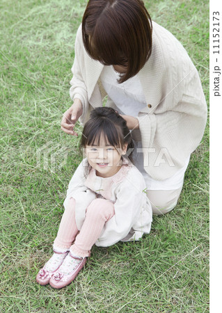 芝生で髪を結う母と子 11152173