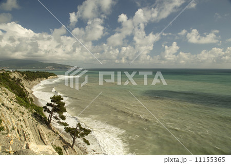 Seascape with a rocky shore, with blue sky and clouds 11155365