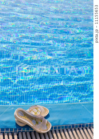 Slippers lies on the brink of pool.. Slippers lies on the brink of pool.. 11155653