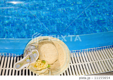 The straw hat lies on the brink of pool 11155654