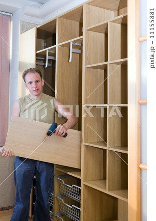 The man is engaged in repair and furniture assemblage.. The man is engaged in repair and furniture assemblage.. 11155881