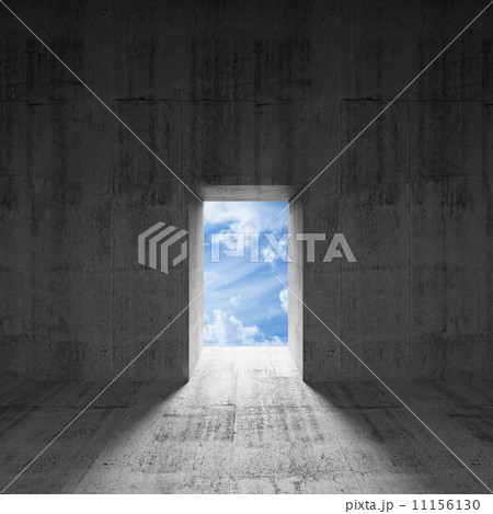 Abstract dark concrete interior with sky behind glowing door 11156130