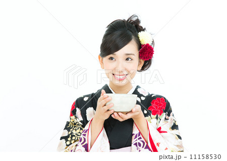 抹茶を飲む振袖の女性の写真素材