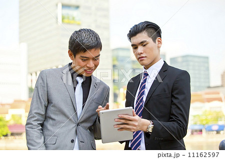 Young business executives looking at tablet in financial hub Young business executives looking at tablet in financial hub 11162597