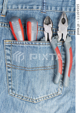 two screwdriver, nippers and pliers in the pocket of jeans 11164505