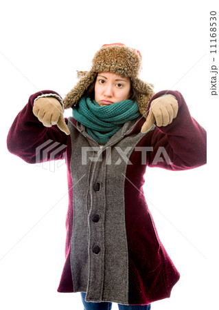 Young woman in warm clothing and showing thumbs down sign with b 11168530