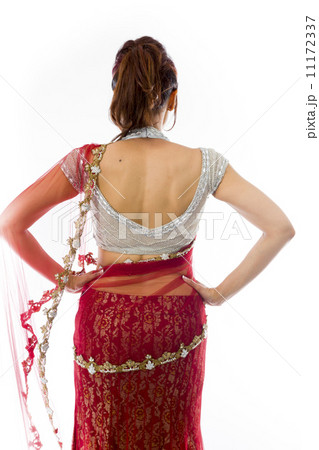 Rear view of a young Indian woman standing with her arms akimbo 11172337