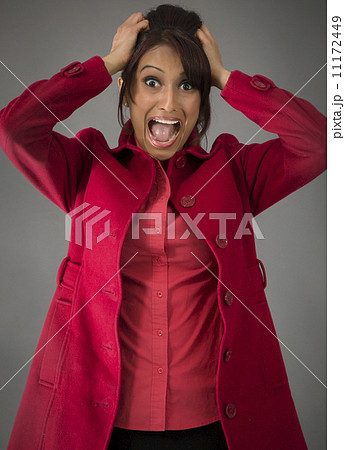 Indian young woman pulling her hair and screaming in frustration Indian young woman pulling her hair and screaming in frustration 11172449