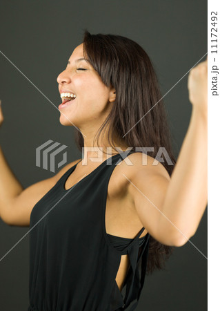 Excited young woman showing fist and celebrating success 11172492