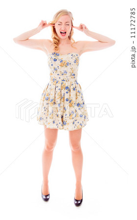 Young woman standing with fingers in her ears Young woman standing with fingers in her ears 11172785