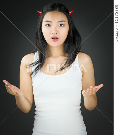 Shocked Asian young woman in devil horns gesturing 11175239