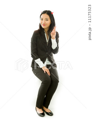 Asian young businesswoman sitting on stool in devil horns with her fingers crossed looking at camera isolated on white background Asian young businesswoman sitting on stool in devil horns with her fingers crossed looking at camera isolated on white background 11175323