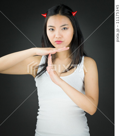 Asian young woman in devil horns making time out signal with hands Asian young woman in devil horns making time out signal with hands 11175345