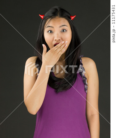 Devil side of a young Asian woman looking shocked Devil side of a young Asian woman looking shocked 11175431