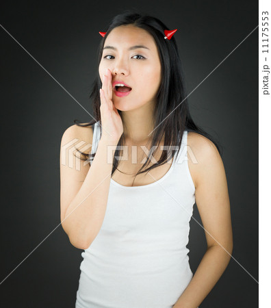 Asian young woman in devil horns whispering Asian young woman in devil horns whispering 11175553