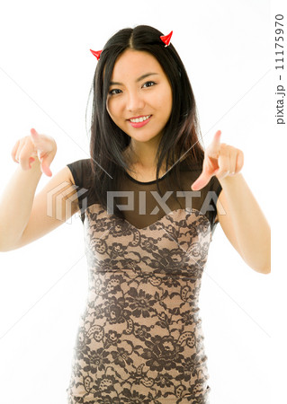Asian young woman dressed up as a devil and pointing towards camera with both hands isolated on white background 11175970