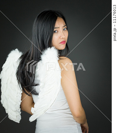 Rear view of a Upset Asian young woman dressed up as an angel tu Rear view of a Upset Asian young woman dressed up as an angel tu 11176013