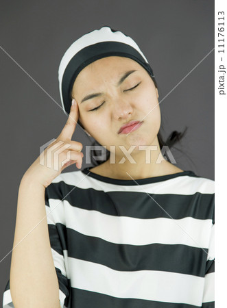 Young Asian woman thinking in prisoners uniform Young Asian woman thinking in prisoners uniform 11176113