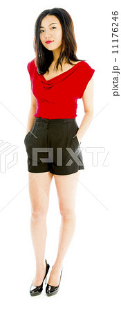 Portrait of a young woman standing with her hands in pockets 11176246