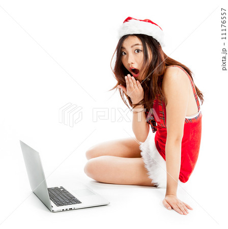 Sexy asian santa claus sitting with laptop and astonished 11176557