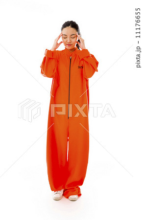Young Asian woman suffering from headache in prisoners uniform Young Asian woman suffering from headache in prisoners uniform 11176655