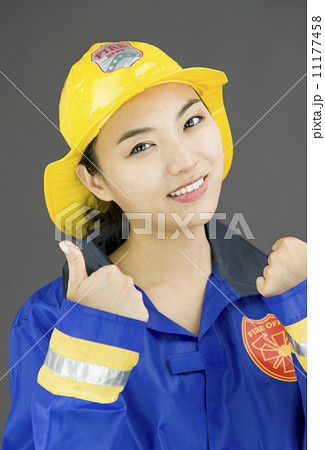 Close up of a confident lady firefighter showing thumbs up sign Close up of a confident lady firefighter showing thumbs up sign 11177458