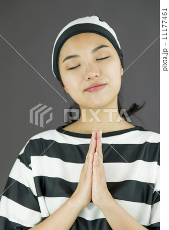 Young Asian woman with prayer position in prisoners uniform 11177461
