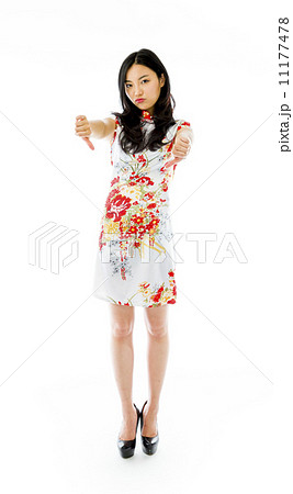 Unhappy Asian young woman giving thumbs down gesture 11177478