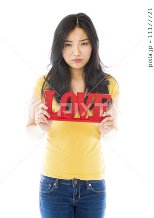 Sad Asian young woman holding a red "LOVE" text Sad Asian young woman holding a red "LOVE" text 11177721