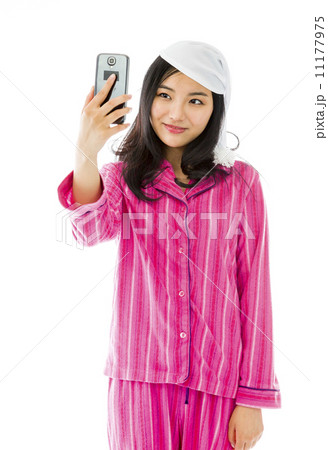 Asian young woman photographing herself with her mobile phone Asian young woman photographing herself with her mobile phone 11177975