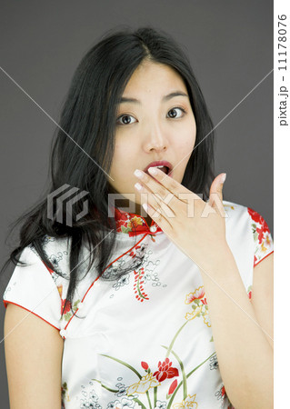 Shocked Asian woman with hand over mouth isolated on colored background Shocked Asian woman with hand over mouth isolated on colored background 11178076