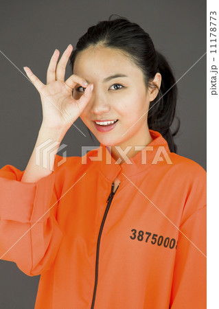 Young Asian woman showing OK sign in prisoners uniform 11178773