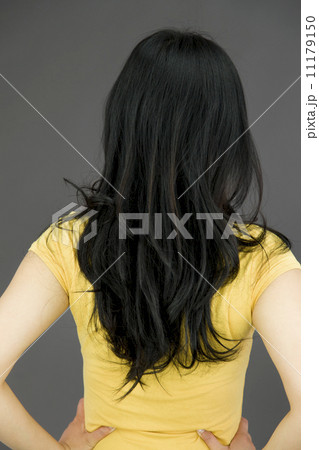 Rear view of a young Asian woman with her arms akimbo 11179150