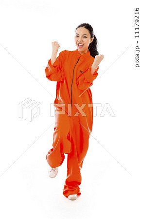 Young Asian woman celebrating success in prisoners uniform Young Asian woman celebrating success in prisoners uniform 11179216
