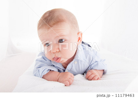 Baby boy lying on the bed and sticking his tongue out Baby boy lying on the bed and sticking his tongue out 11179463