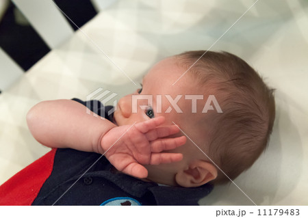 Close-up of a baby boy lying in a crib 11179483
